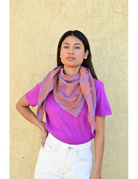 Bandana Galatie motifs floraux oranges porté autour du cou.