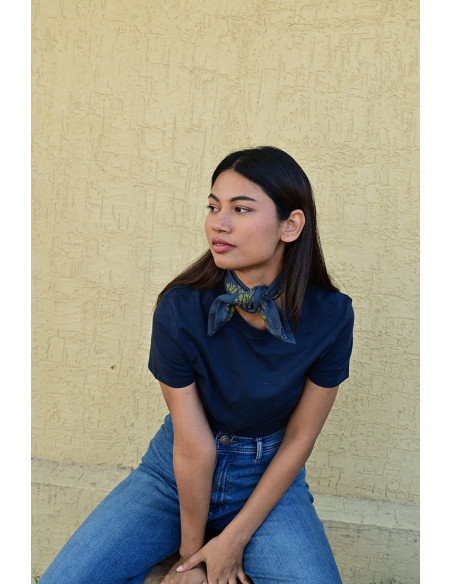 Bandana Galatie motifs floraux jaunes noué autour du cou.