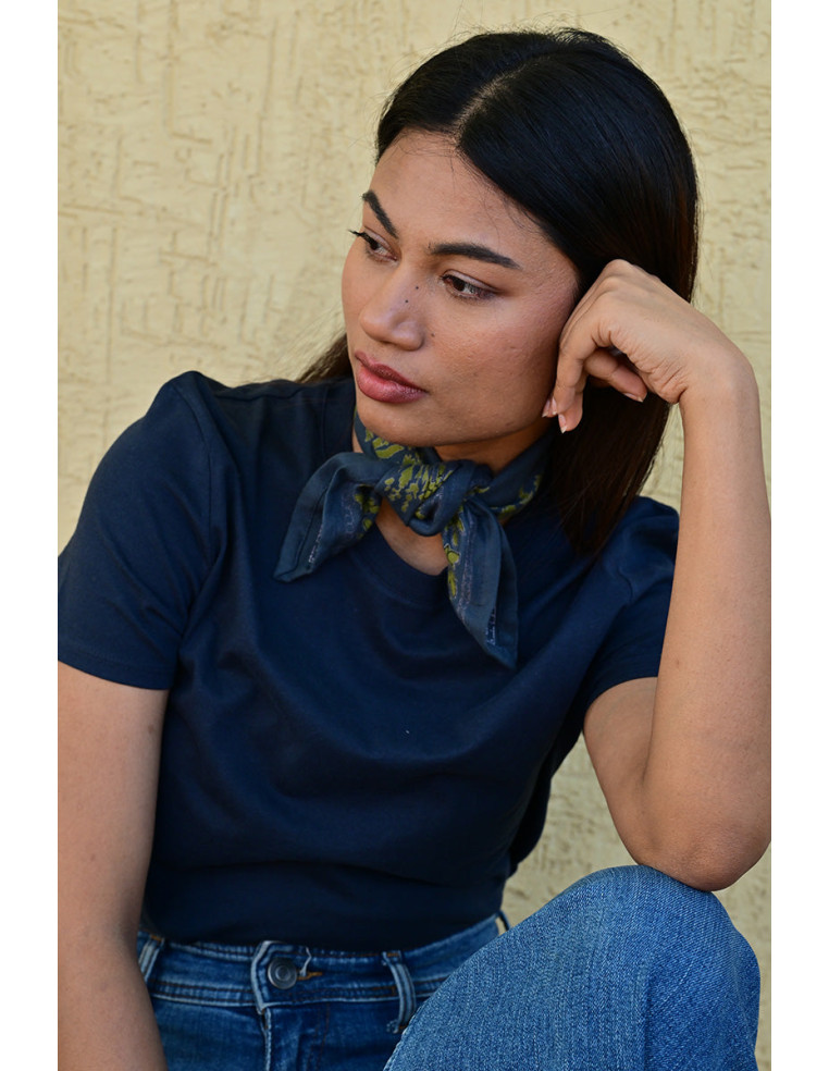 Bandana Galatie motifs floraux jaunes noué autour du cou.