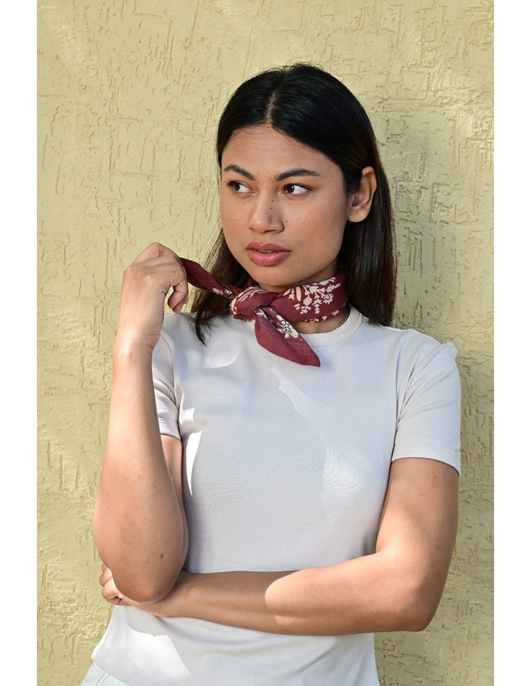 Bandana Galatie motifs floraux écru porté noué autour du cou.