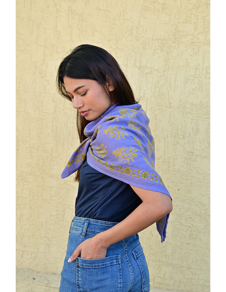 Bandana Galatie motifs floraux ocres porté autour du cou.