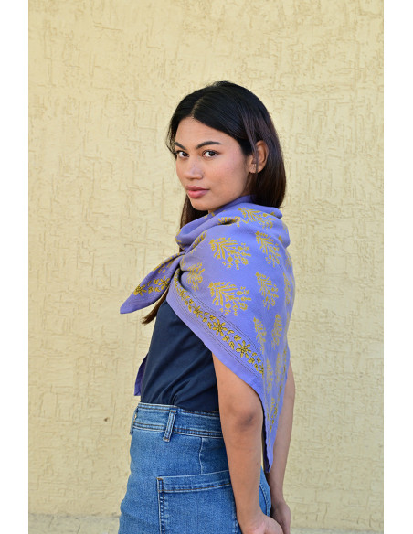 Bandana Galatie motifs floraux ocres porté autour du cou.