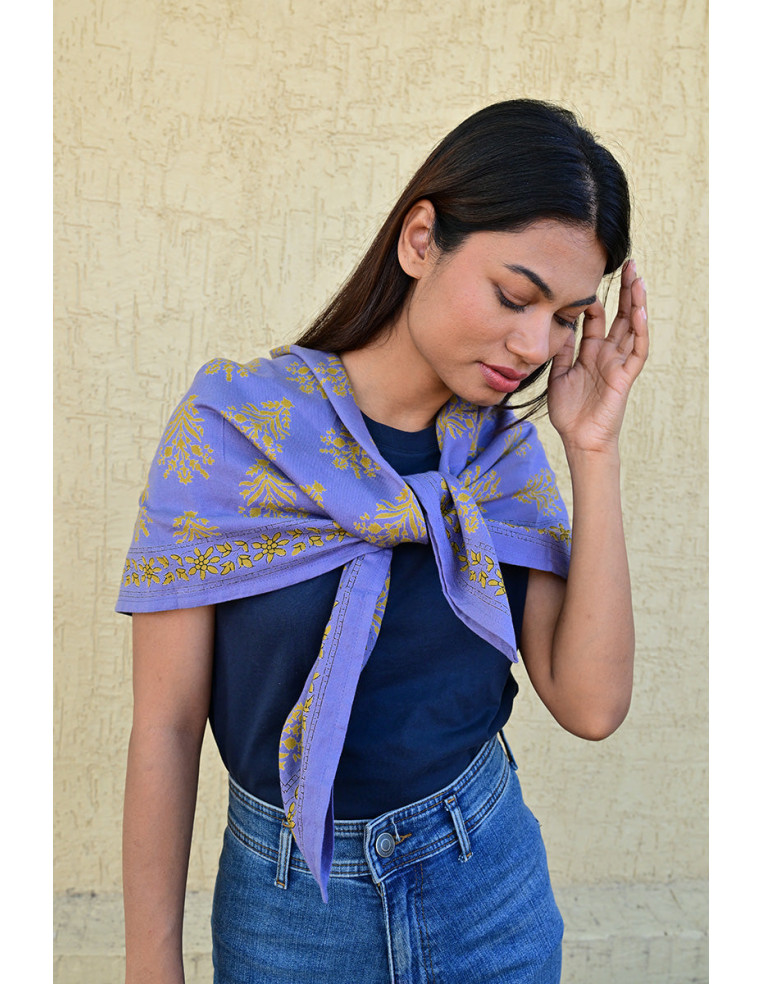 Bandana Galatie motifs floraux ocres porté autour du cou.