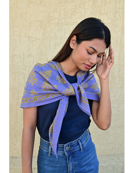 Bandana Galatie motifs floraux ocres porté autour du cou.