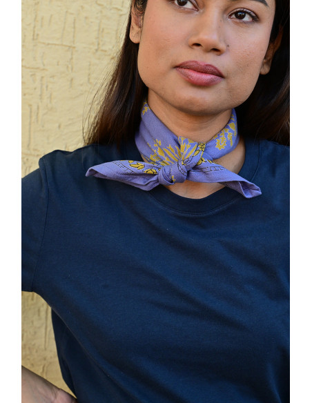 Bandana Galatie motifs floraux ocres porté autour du cou.