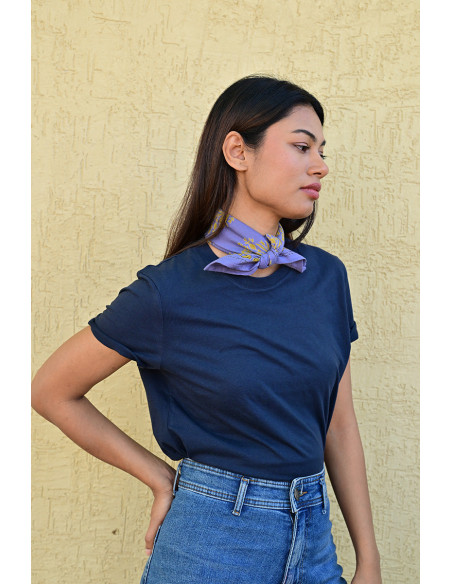 Bandana Galatie motifs floraux ocres porté autour du cou.