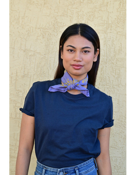 Bandana Galatie motifs floraux ocres porté autour du cou.