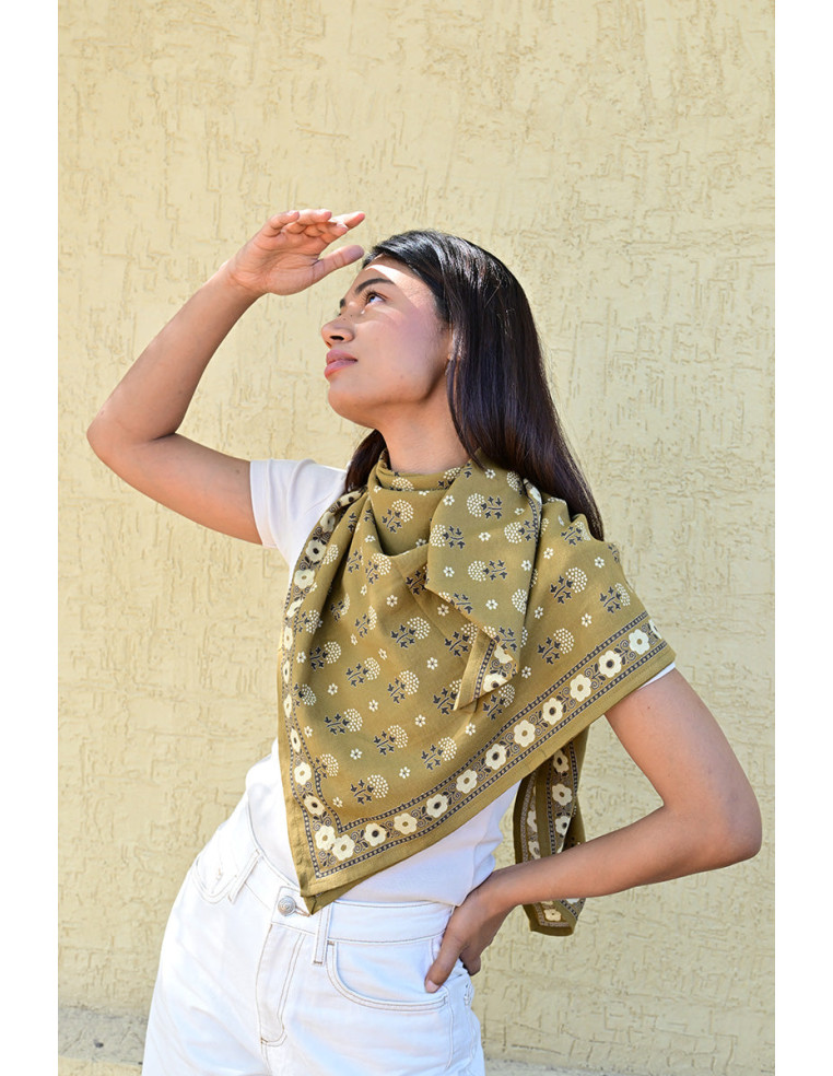 Femme portant le grand foulard Anastase bistre 100x100 cm autour du cou.